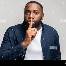 A person holding a finger to their lips in a request for silence.