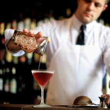 A bartender serving drinks from behind a bar.