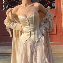 A vintage corset displayed as a close-fitting torso garment.