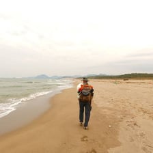 A solitary person viewing a distant landscape from abroad