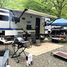 Campers putting up tents at a campsite.