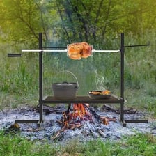 Meat turning on a spit over a barbecue fire.
