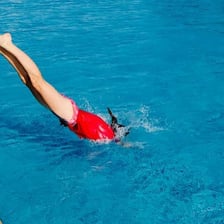 A person diving into a swimming pool