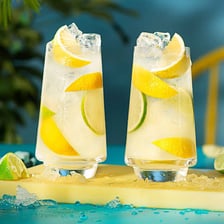 A chilled glass of lemonade with lemon slices.