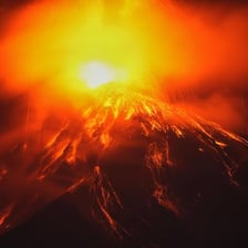 Red lava flowing down the side of a volcano