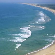 A broad briny body of water with waves extending toward the horizon.