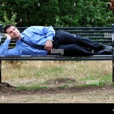 A person idly lounging on a park bench.