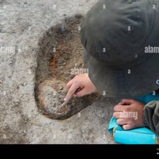 An archaeologist revealing an artifact by removing soil