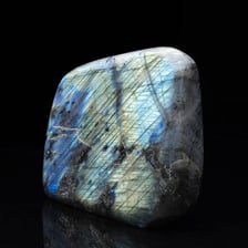 A polished labradorite stone displaying blue iridescent flashes.