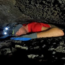 A person exploring the interior of an underground cave.