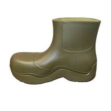 A rubber galosh standing beside a rain puddle