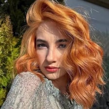 Person showing warm reddish-golden strawberry blonde hair