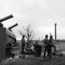 A historical scene showing soldiers and military vehicles during wartime