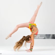 A gymnast performing a somersault on a padded floor