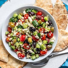 A Greek salad topped with crumbled white feta cheese.