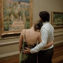 A visitor studying paintings in an art gallery