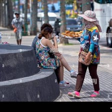 A street vendor actively offering merchandise to passersby.