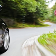 A vehicle traveling dangerously fast on a road.