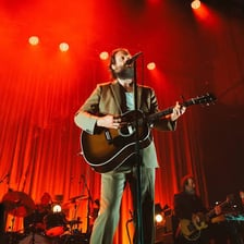 Musician Father John Misty performing onstage.