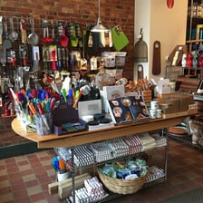 A department-store aisle displaying cookware, dishes, and other household goods.