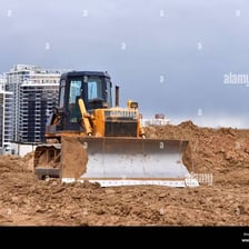 A bulldozer pushing debris while demolishing a structure