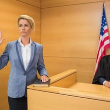 A witness giving testimony after taking an oath in a courtroom