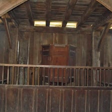 A stark, sparsely furnished interior associated with Puritan austerity.