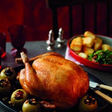 A roast turkey surrounded by traditional Thanksgiving side dishes