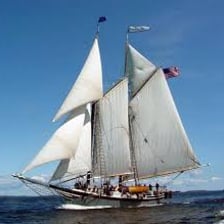 A schooner sailing on open water with multiple masts and fore-and-aft sails.