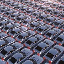 Rows of stationary cars parked in a lot.