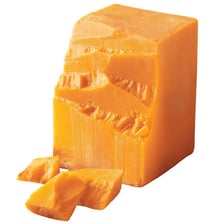 A wedge of aged sharp cheddar cheese