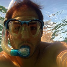 Swimmer wearing a mask and breathing through a snorkel.