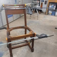 A chair held together with a temporary repair.