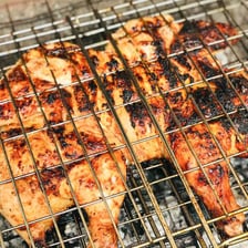 A chicken shown being split and flattened for barbecue cooking