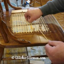 A close-up view of cane strips woven into a chair seat