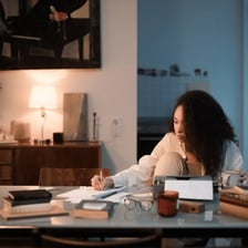 A novelist writing a manuscript at a desk.