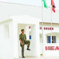 A soldier standing watch at a guarded military post