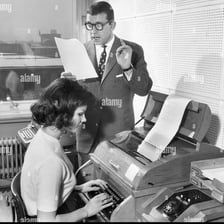 A person speaking while a secretary records the words.