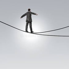 A person carefully crossing a precarious tightrope