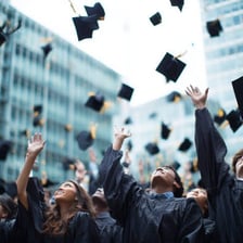 Graduates tossing academic caps into the air