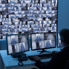 A person watching several security camera screens