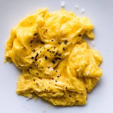 Soft scrambled eggs with a visibly liquid, runny texture.
