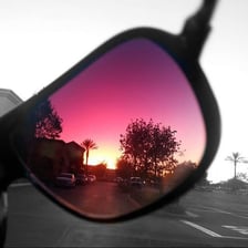 Rose-tinted glasses casting a pink hue over the scene beyond them.