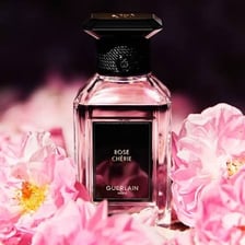 A bottle of rosewater displayed with fresh roses