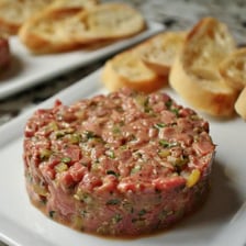A plated serving of steak tartare made from finely chopped raw beef.