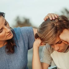 An adult reassuring a visibly anxious child