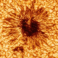 A dark sunspot visible on the Sun’s bright surface.