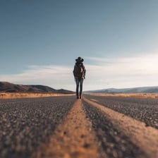 A carefree person traveling alone along a scenic path