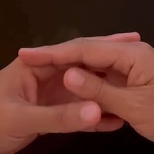 A person idly moving their thumbs together.