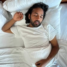 A person lounging idly in bed during the morning